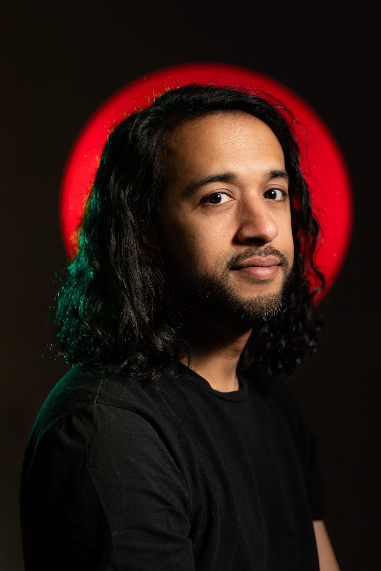 Photo Profil David Lavana portrait studio sur fond rouge et vert