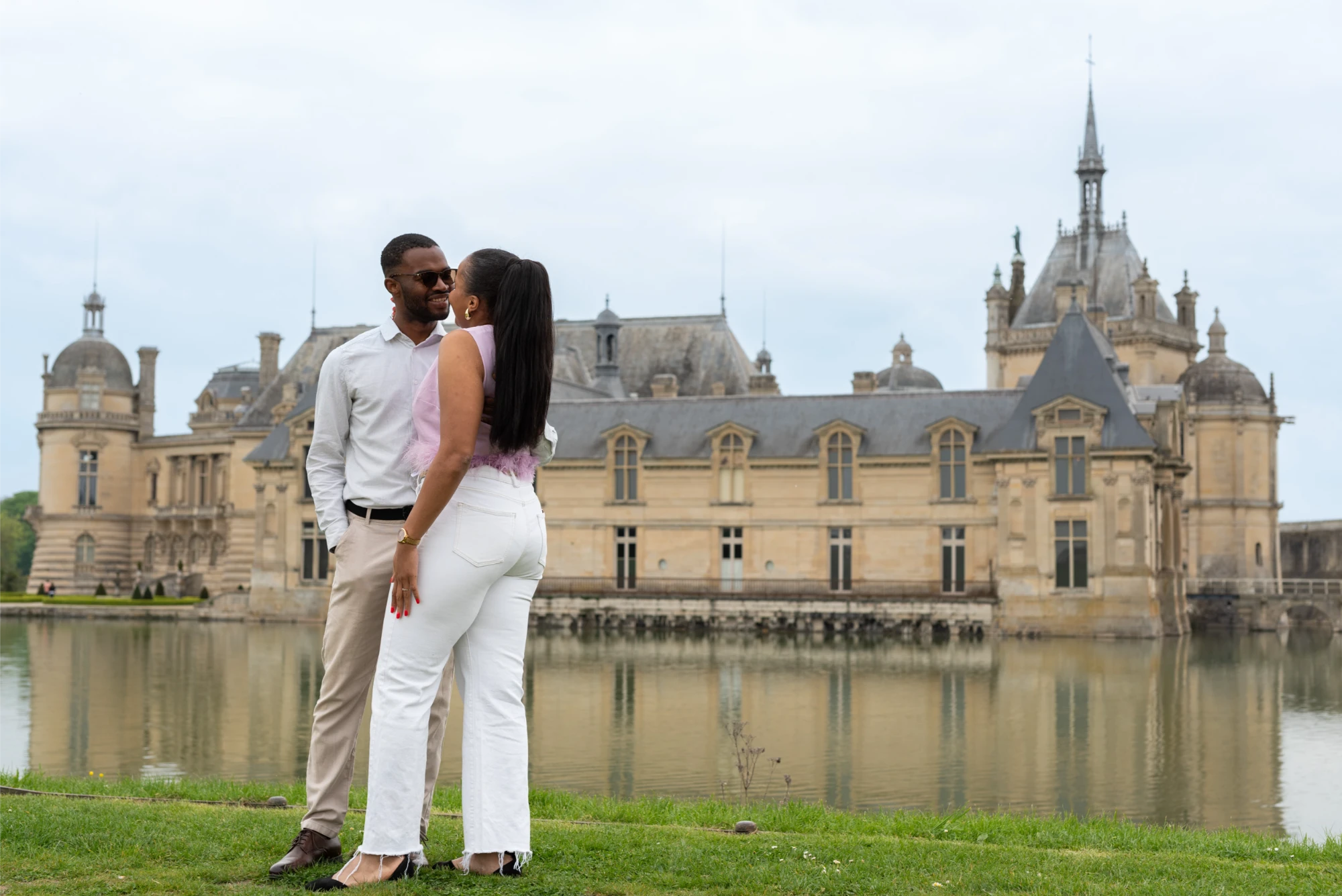 Un couple amoureux s'enlace devant le ch&acirc;teau de Chantilly